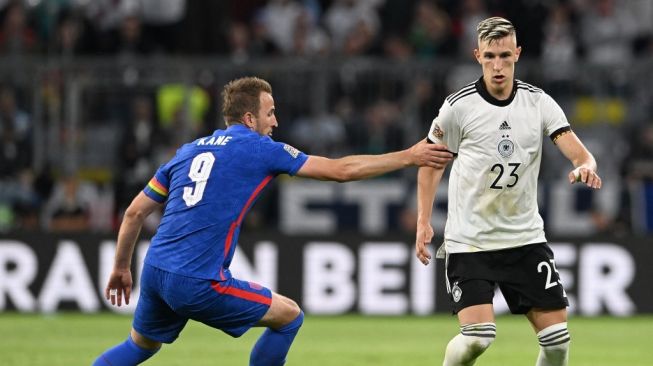 Penyerang timnas Inggris Harry Kane (kiri) dan bek Jerman Nico Schlotterbeck berebut bola dalam matchday kedua UEFA Nations League 2022-2023 antara Jerman vs Inggris di Munich, Jerman selatan pada 7 Juni 2022.CHRISTOF STACHE / AFP.