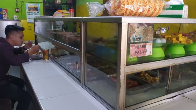 Sebuah warteg di Kota Cimahi terpaksa menaikan harga makanan berbahan telur ayam meski harus menerima banyak komplain dari pelanggan. [Suara.com/Ferrye Bangkit Rizki]