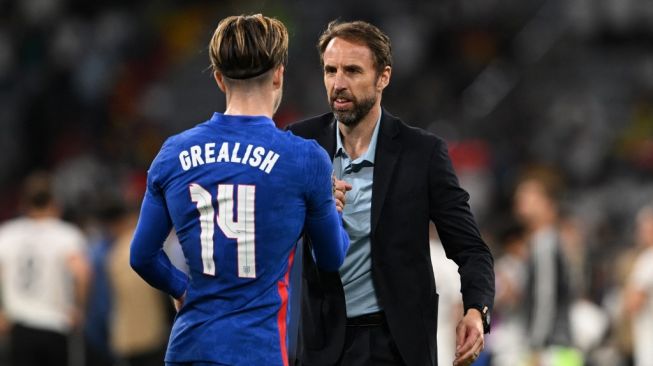 Gelandang serang Timnas Inggris, Jack Grealish (kiri) bersama pelatih Gareth Southgate usai laga UEFA Nations League kontra Jerman di Allianz Arena, Munich, Rabu (8/6/2022). [CHRISTOF STACHE / AFP]