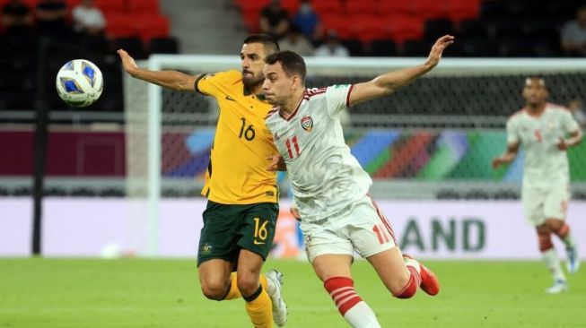 Gelandang Australia Ajdin Hrustic menggiring bola dibayangi pemain Uni Emirat Arab Caio Canedo dalam laga kualifikasi akhir zona Asia di Al Rayyan Stadium, Doha, Qatar, Selasa (7/6/2022). ANTARA/REUTERS/Mohammed Dabbous