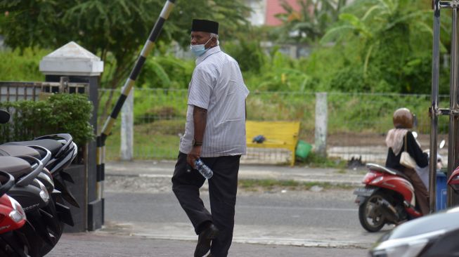 Terdakwa Kepala Bidang Pembibitan dan Produksi Dinas Peternakan Aceh, Alimin Hasan, berjalan menuju pintu keluar seusai sidang dengan agenda pembacaan putusan majelis hakim di Pengadilan Tipikor Banda Aceh, Aceh, Selasa (7/6/2022). [ANTARA FOTO/Ampelsa/foc]