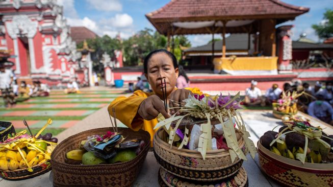 Umat Hindu mempersembahkan sesajen saat Hari Raya Galungan di Pura Agung Sriwijaya, Palembang, Sumatera Selatan, Rabu (8/6/2021). [ANTARA FOTO/Nova Wahyudi/rwa]