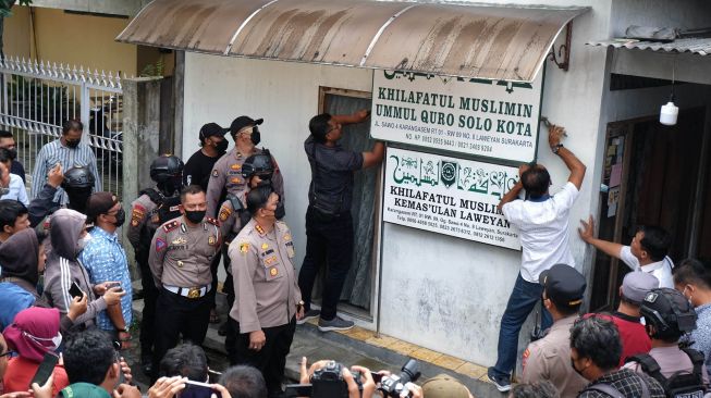 Polisi menurunkan papan bertulis Khilafatul Muslimin dari rumah warga sekaligus kantor cabang kelompok tersebut di Solo, Jawa Tengah, Kamis (9/6/2022). ANTARAFOTO/Maulana Surya
