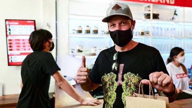 Pelanggan berbelanja di dalam Highland Cafe pada hari pertama penghapusan ganja dari daftar narkotika berdasarkan hukum Thailand di Bangkok, Thailand, (9/6/2022). Manan VATSYAYANA / AFP

