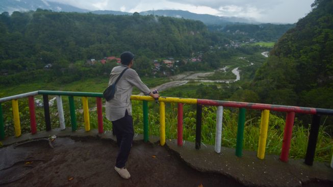 Warga menikmati panorama dari tempat yang tanahnya terancam amblas di objek wisata Janjang Saribu, Bukit Apit Puhun, Kota Bukittinggi, Sumatera Barat, Jumat (10/6/2022).  ANTARA FOTO/Iggoy el Fitra