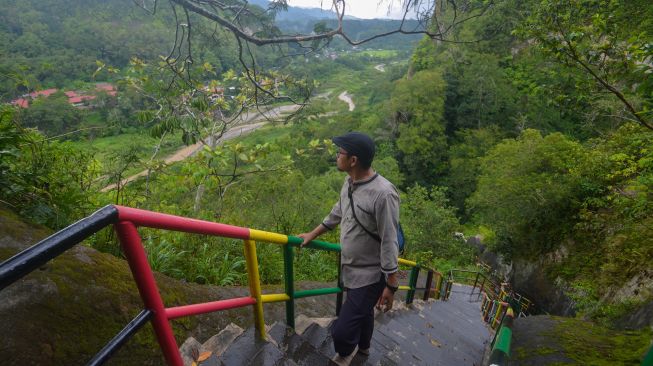 Warga menikmati panorama dari tempat yang tanahnya terancam amblas di objek wisata Janjang Saribu, Bukit Apit Puhun, Kota Bukittinggi, Sumatera Barat, Jumat (10/6/2022).  ANTARA FOTO/Iggoy el Fitra