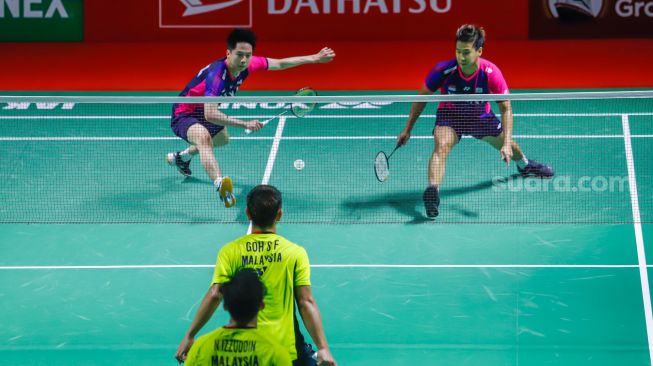 Pebulu tangkis ganda putra Indonesia Marcus Gideon dan Kevin Sanjaya melakukan serangan kepada pebulu tangkis ganda putra Malaysia Goh Sze Fei dan Nur Izzuddin  pada babak perempat final Daihatsu Indonesia Master 2022 di Istora Senayan,  Jakarta Pusat, Jumat (10/6/2022). [Suara.com/Alfian Winanto]