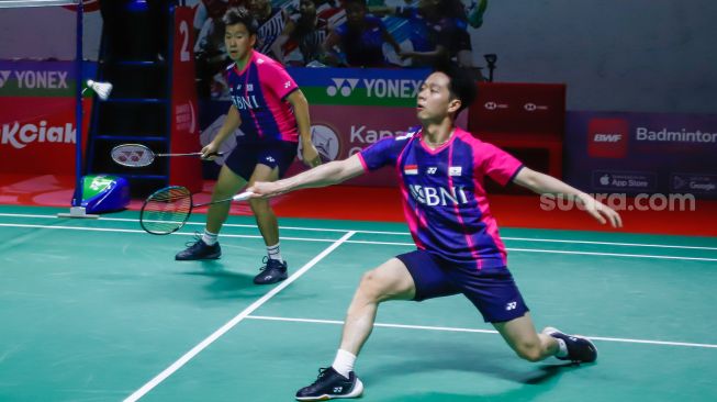 Pebulu tangkis ganda putra Indonesia Marcus Gideon dan Kevin Sanjaya melakukan serangan kepada pebulu tangkis ganda putra Malaysia Goh Sze Fei dan Nur Izzuddin  pada babak perempat final Daihatsu Indonesia Master 2022 di Istora Senayan,  Jakarta Pusat, Jumat (10/6/2022). [Suara.com/Alfian Winanto]