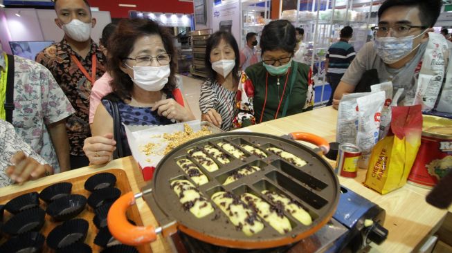 Pengunjung menyaksikan proses pembuatan kue pukis di salah satu stan pameran dalam Indonesia Food Exhibition 2022 di Surabaya, Jawa Timur, Jumat (10/6/2022). [ANTARA FOTO/Moch Asim/nym]