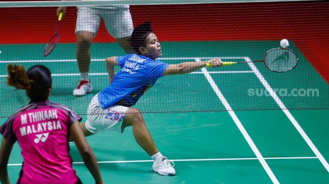 Pebulu tangkis ganda putri Indonesia Apriyani Rahayu dan Siti Fadia Ramadhanti melakukan serangan kepada pebulu tangkis ganda putri Malaysia Pearly Tan dan Thinaah Muralitharan pada semi final Daihatsu Indonesia Master 2022 di Istora Senayan,  Jakarta Pusat, Sabtu (11/6/2022). [Suara.com/Alfian Winanto]