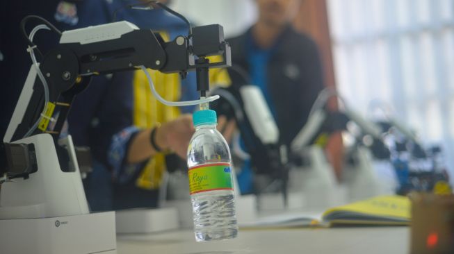 Guru menunjukan kemampuan robot memindahkan barang secara otomatis, saat sosialisasi di SMK Pembangunan Teknologi Robotik UNP di Padang, Sumatera Barat, Sabtu (11/6/2022). [ANTARA FOTO/Iggoy el Fitra/foc]
