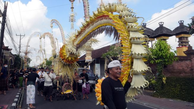 Umat Hindu membawa penjor atau bambu yang dihiasi janur dan hasil bumi untuk dilombakan dalam festival penjor dengan tema "ngerobok" di Desa Adat Kerobokan, Badung, Bali, Sabtu (11/6/2022). [ANTARA FOTO/Nyoman Hendra Wibowo/foc]