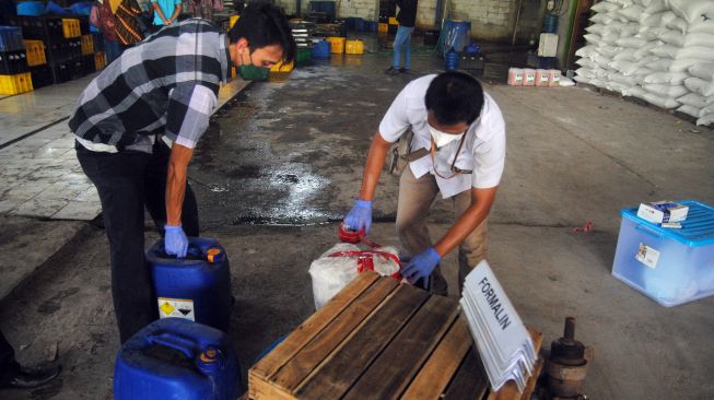 Dua petugas Badan Pengawas Obat dan Makanan (BPOM) mengamankan barang bukti formalin di pabrik tahu SBJ, Kampung Waru Kaum, Desa Waru Jaya, Kecamatan Parung, Kabupaten Bogor, Jawa Barat, Jumat (10/6/2022). [ANTARA FOTO/Arif Firmansyah/nym]
