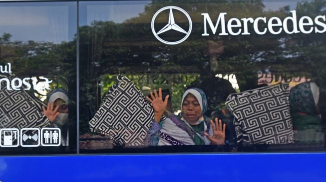 Sejumlah calon haji melambaikan tangan kepada sanak keluaerganya saat diberangkatkan dari Alun-alun Serang, Banten, Minggu (12/6/2022). ANTARA FOTO/Asep Fathulrahman
