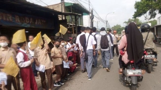 Mengharukan! Anak Sekolah Berseragam SD Kibarkan Bendera Kuning untuk Eril, Iringi Jenazah Eril ke Rumah Terakhir