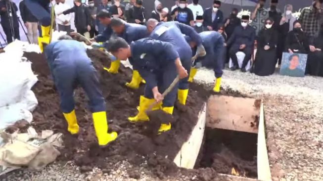 Ridwan Kamil menjadi orang yang pertama masukkan tanah ke liang lahat Eril di Pemakaman Cimaung Bandung. (Humas Pemprov Jabar)