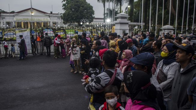 Warga menunggu kedatangan jenazah almarhum Emmeril Kahn Mumtadz di depan gerbang Gedung Pakuan, Bandung, Jawa Barat, Minggu (12/6/2022). ANTARA FOTO/Novrian Arbi