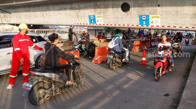 Pengendara motor melintas di Jembatan Antelope, Curug, Bekasi, Jawa Barat, Selasa (14/6/2022). [Suara.com/Alfian Winanto]