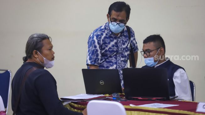 Petugas melayani warga yang berkonsultasi terkait pendaftaran daring Penerimaan Peserta Didik Baru (PPDB) 2022 di Posko Pelayanan PPDB SMA Negeri 70 Jakarta Selatan, Jakarta, Selasa (14/6/2022). [Suara.com/Alfian Winanto]