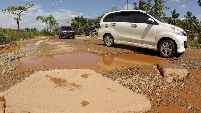 Sejumlah kendaraan melintasi jalan lintas industri yang rusak dan berlubang di Kabil, Batam, Kepulauan Riau, Selasa (14/6/2022). ANTARA FOTO/Teguh Prihatna
