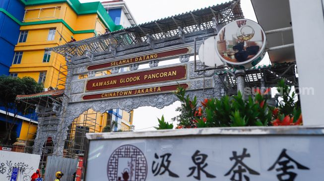 Pekerja menyelesaikan pembangunan konstruksi proyek gapura Chinatown di Glodok, Jakarta Barat, Selasa (14/6/2022). [Suara.com/Alfian Winanto]