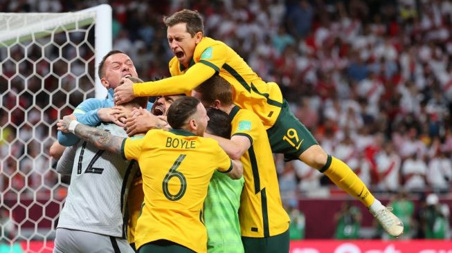 Para pemain Australia bergembira usai memenangi adu penalti laga play-off inter-konfederasi Piala Dunia 2022 melawan Peru di Al-Rayyan Stadium, Qatar, Selasa (14/6/2022). [KARIM JAAFAR / AFP]