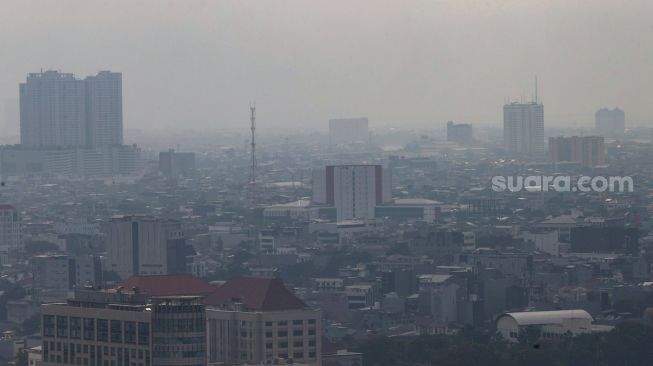 Kabut polusi udara menyelimuti gedung-gedung bertingkat di Jakarta, Rabu (15/6/2022). [Suara.com/Alfian Winanto]