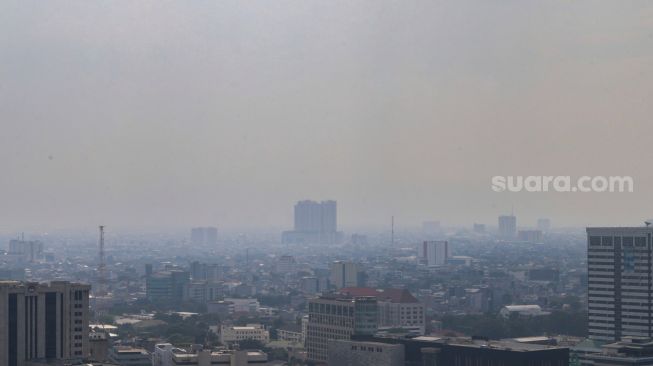 Kabut polusi udara menyelimuti gedung-gedung bertingkat di Jakarta, Rabu (15/6/2022). [Suara.com/Alfian Winanto]