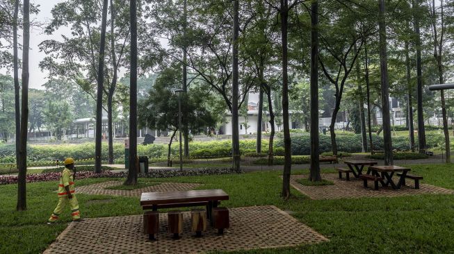 Petugas kebersihan berjalan di Tebet Eco Park, Jakarta, Rabu (15/6/2022). ANTARA FOTO/Aprillio Akbar

