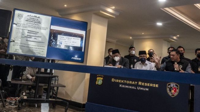 Direktur Reserse Kriminal Umum Polda Metro Jaya Kombes Hengki Haryadi (kanan) menujukkan barang bukti dalam keterangan pers terkait penanganan perkara ormas Khilafatul Muslimin di Polda Metro Jaya, Jakarta, Kamis (16/6/2022). [ANTARA FOTO/Aprillio Akbar]