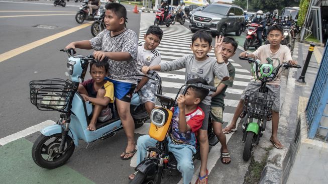 Sejumlah bocah mengendarai motor listrik di jalan raya di Jakarta, Kamis (16/6/2022).  ANTARA FOTO/Muhammad Adimaj