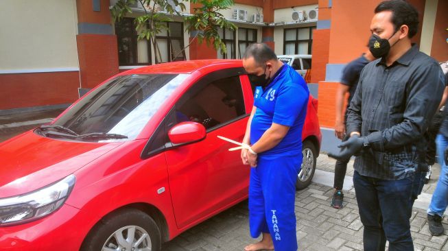 Anggota polisi menunjukkan seorang tersangka polisi gadungan beinisial AA dan barang bukti satu unit mobil saat rilis kasus di Polres Kudus, Jawa Tengah, Kamis (16/6/2022).  ANTARA FOTO/Yusuf Nugroho