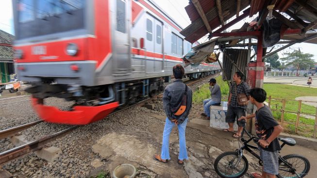 Warga menjaga perlintasan sebidang Kereta Api (KA) liar di Jalan Paseban, Bojong Gede, Kabupaten Bogor, Jawa Barat, Kamis (16/6/2022).  ANTARA FOTO/Yulius Satria Wijaya