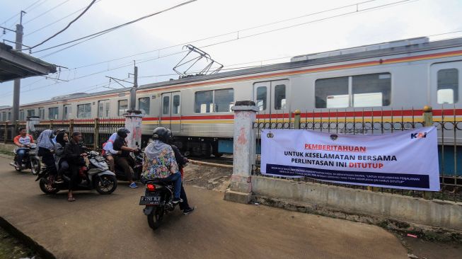 Pengendara menunggu kereta melintas di perlintasan sebidang Kereta Api (KA) liar di Jalan Paseban, Bojong Gede, Kabupaten Bogor, Jawa Barat, Kamis (16/6/2022).  ANTARA FOTO/Yulius Satria Wijaya