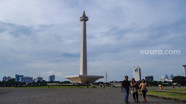 Warga berwisata mengunjungi Monumen Nasional (Monas) di Gambir, Jakarta Pusat, Kamis (16/6/2022). [Suara.com/Alfian Winanto]