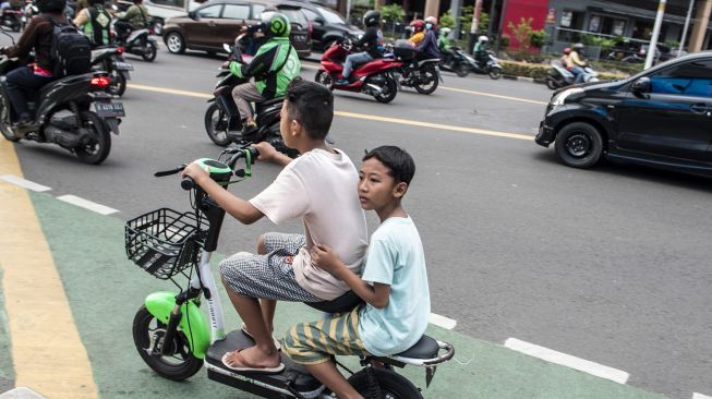 Sejumlah bocah mengendarai motor listrik di jalan raya di Jakarta, Kamis (16/6/2022).  ANTARA FOTO/Muhammad Adimaj