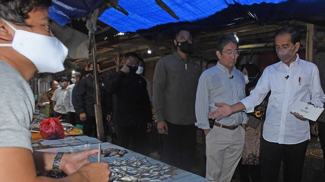 Presiden Joko Widodo (kanan) berbincang dengan pedagang ikan saat mengunjungi Pasar Tradisional di Baros, Serang, Banten, Jumat (17/6/2022). [ANTARA FOTO/Asep Fathulrahman/ foc]
