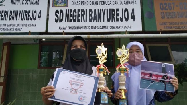 Guru di SD N Banyurejo 4 menunjukkan piala dan piagam prestasi milik peserta didik mereka, di halaman sekolah setempat, Jumat (17/6/2022). (kontributor/uli febriarni)