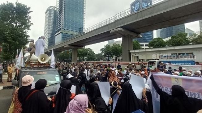 Sejumlah massa melakukan aksi unjuk rasa di lokasi terkat dugaan penghinaan Nabi Muhammad SAW. (Suara.com/Arga)