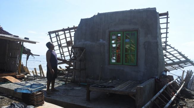 Warga mengamati rumah yang rusak terkena banjir rob atau air laut pasang di Desa Landangan, Kapongan, Situbondo, Jawa Timur, Jumat (17/6/2022). [ANTARA FOTO/Seno/foc]
