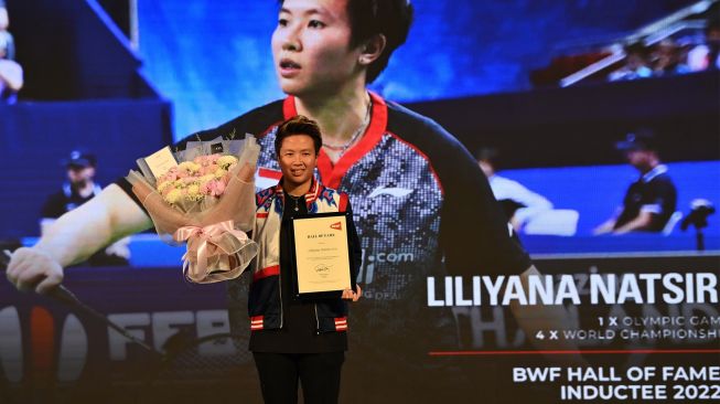 Mantan pebulu tangkis ganda campuran Indonesia Liliyana Natsir menunjukkan piagam Hall of Fame dari Federasi Bulu Tangkis Dunia (BWF) di Istora Senayan, Jakarta, Sabtu (18/6/2022). [ANTARA FOTO/Sigid Kurniawan/YU]
