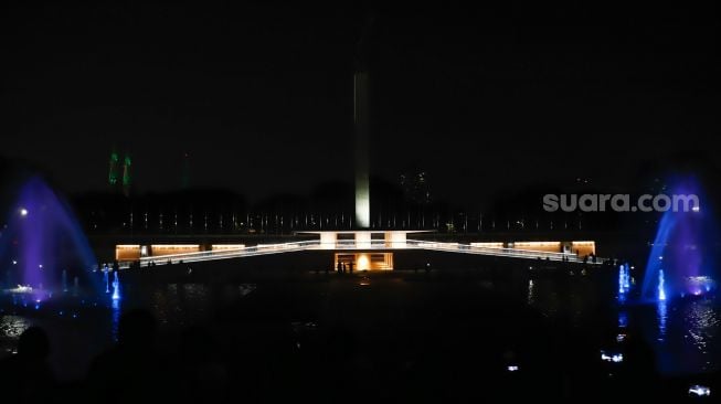 Warga menonton pertunjukan air mancur di Taman Lapangan Banteng, Jakarta Pusat, Sabtu (18/6/2022). [Suara.com/Alfian Winanto]