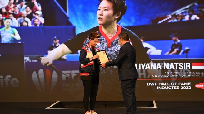 Mantan pebulu tangkis ganda campuran Indonesia Liliyana Natsir (kiri) menerima piagam Hall of Fame dari Federasi Bulu Tangkis Dunia (BWF) dari Anggota Dewan BWF Bambang Roedyanto di Istora Senayan, Jakarta, Sabtu (18/6/2022). [ANTARA FOTO/Sigid Kurniawan/YU]