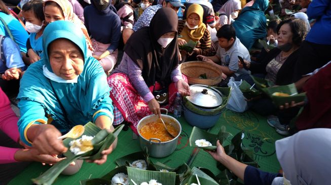 Anggota Forum Budaya Mataram membagikan nasi liwet kepada warga saat acara pengukuhan nasi liwet sebagai ikon kuliner Kota Solo di Balai Kota Solo,Jawa Tengah, Minggu (19/6/2022). ANTARA FOTO/Maulana Surya