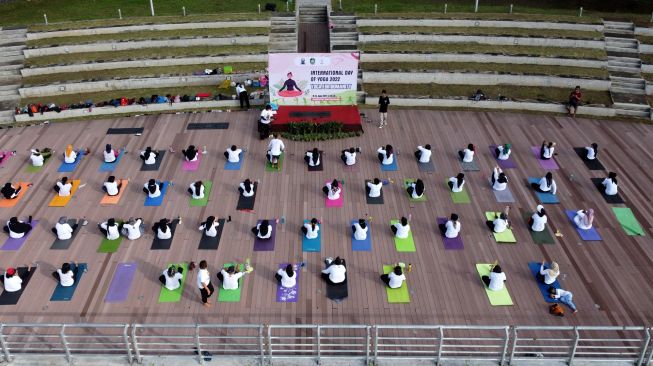 Foto udara warga melakukan gerakan yoga di Pulau Wangi Pantai Boom, Banyuwangi, Jawa Timur, Minggu (19/6/2022).  ANTARA FOTO/Budi Candra Setya