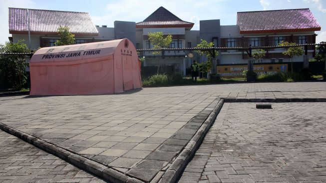 Petugas keamanan berjaga di depan Rumah Sakit Darurat Lapangan (RSDL), Bangkalan, Jawa Timur, Selasa (21/6/2022).  ANTARA FOTO/Patrik Cahyo Lumintu