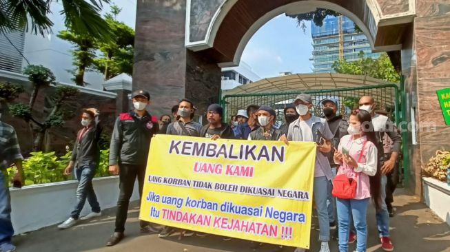 Para korban dari Indra Kenz dan Doni Salmanan menggelar aksi unjuk rasa di depan Gedung Kejaksaan Agung, Jakarta Selatan, Selasa (21/6/2022) [Suara.com/Rena Pangesti]