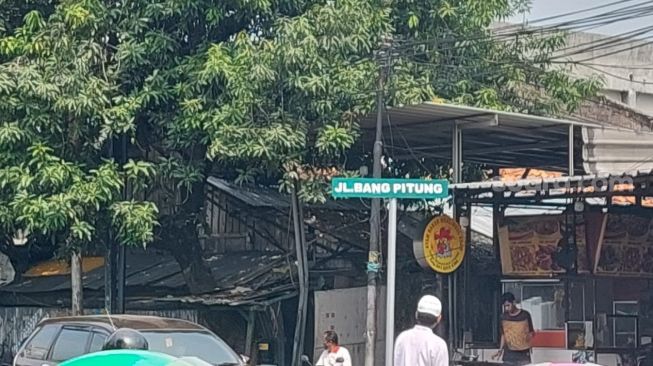 Jalan Bang Pitung di pertigaan lampu merah Rawa Belong, Jakarta Barat, yang kini menggantikan nama Jalan Raya Kebayoran Lama, Selasa (21/6/2022). [Suara.com/Faqih Fathurrahman]