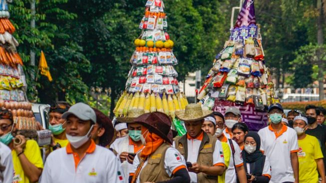 Peserta pawai budaya berjalan mengitari kawasan Taman Lapangan Banteng, Jakarta Pusat, Rabu (22/6/2022). [Suara.com/Alfian Winanto]