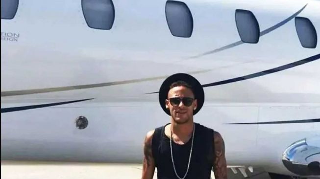 Neymar berpose di depan jet pribadinya. [Instagram/@Neymarjr]